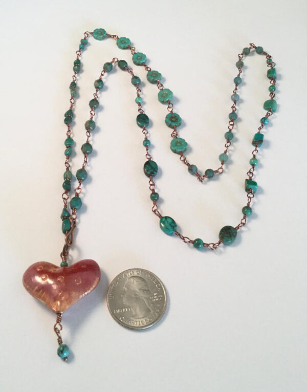 a copper heart pendant on a beaded chain
